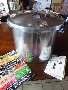 a stainless steel ice bucket sitting on top of a wooden table next to books and magazines