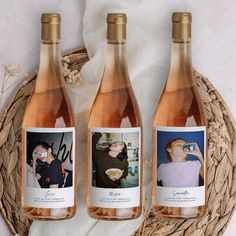 three bottles of wine sitting on top of a basket next to each other with photos