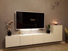 a flat screen tv sitting on top of a white entertainment center in a living room