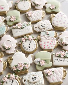 decorated cookies are arranged in the shape of teapots and other things on display