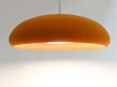 an orange pendant light hanging from a ceiling