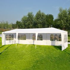 a large white tent set up in the middle of a field with windows on it