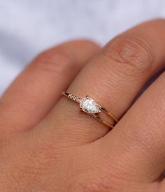 a woman's hand with a diamond ring on top of her finger and an engagement band