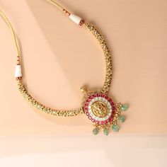 Description: Cascading demurely down the feminine cleft, this elegant hasli combines classic temple patterns of flora and ivy with a handcrafted nakshi depicting Lord Ganesha motif at the apex. Kempu stones set in jadau style and gemstone beads drop adorn the necklace to create a symphony of vivid colors in this unique piece. Product Information Materials used: 925 Silver with 1.0-microns Antique Gold Plating Stones: Semi precious stones Length: 13.5 cm Findings: Hook & links Navratri Necklaces With Zari Work, Elegant Bridal Necklace With Peacock Design For Puja, Elegant Necklaces With Zari Work For Rituals, Elegant Bridal Necklace With Zari Work For Puja, Fusion Style Kundan Temple Necklace With Intricate Design, Fusion Style Temple Necklace With Intricate Kundan Design, Navratri Temple Jewelry Necklace With Zari Work, Temple Jewelry Necklace With Zari Work For Navratri, Temple Jewelry Necklace With Zari Work