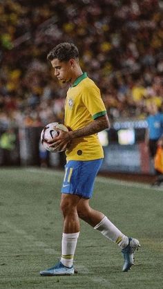 a man holding a soccer ball on top of a field