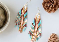 These perfectly joyful and beautiful unique earrings are the perfect way to show off your love of the harvest season. An unexpected combination of pearl, maize, peach, brown and turquoise this pair is reminiscent of flint corn and brings all the fall vibes. Beautiful on any skin tone or hair color. Details: Handcrafted by artisans in Medellin, ColombiaMaterials: Seed beads, stainless steel hardware for comfort and longevitySize: Approximately 3.5 inches from top of hook, 1 inch wideSKU: E1144 FO Earthy Multicolor Earrings Perfect For Gifts, Earthy Multicolor Earrings For Gift, Earthy Handmade Multicolor Earrings, Flint Corn, State Of Tennessee, Harvest Season, Unique Earrings, Fall Vibes, Skin Tones