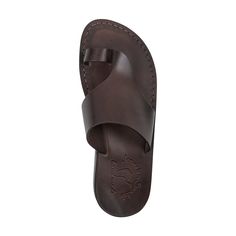 Embrace the sleek contours of the 'Petra' sandal, a silhouette that perfectly balances modern design with classic comfort. Crafted from smooth, full-grain brown leather, this sandal offers a chic and streamlined appearance that complements any outfit. The 'Petra' is a testament to skilled craftsmanship, with a form-fitting design that promotes natural foot movement. Its padded footbed provides a soft, cushioned feel, ideal for day-long wear. A simple, elegant toe loop and a wide upper strap ensu Classic Leather Toe Post Flip Flops, Classic Open Toe Sandals, Classic Brown Slingback Sandals With Round Toe, Brown Footbed Sandals With Single Toe Strap For Summer, Brown Open Toe Sandals With Heel Loop, Classic Leather Toe Loop Flip Flops, Classic Brown Flip Flops For The Beach, Classic Brown Flip Flops For Beach, Leather Sandals With Single Toe Strap And Leather Lining