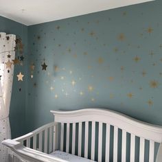 a baby's room with stars painted on the wall and crib bedding