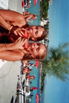 two women standing next to each other on the beach