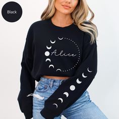 Embrace the enchanting allure of the night sky with our Personalized Mystic Moon Phases Sweatshirt (print sleeve). Adorned with intricate sleeve designs depicting the lunar cycle in shimmering gold, this cozy sweater is more than just apparel--it's a celestial masterpiece. Perfect for the dreamers and stargazers in your life, this mystical sweatshirt is a thoughtful gift that captures the magic of the moonlit sky. 👉 Unisex Sweatshirt Gildan 18000 - Unisex heavy blend crewneck sweatshirt is pure Trendy Moon Print Crew Neck Top, Black Celestial Crew Neck Top, Black Long Sleeve Top With Moon Print, Sweater With Name, Moon Phase Shirt, Moon Sweater, Celestial Graphic Print Crew Neck T-shirt, Moon Print Relaxed Fit Crew Neck T-shirt, Mystical Moon Shirt