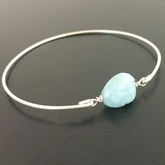 "Larimar Nugget Bead Bracelet - Light Blue Bracelet Bangle. Each Larimar nugget is a little different in its light blue color placement and faint white veining but all of them are incredible. They remind me of light foamy ocean waves. Each bead is about 14mm in size and will be transformed into an elegant Larimar beaded bangle bracelet with your choice of bangle band in sterling silver, silver filled, brass, 14k gold filled or 14k rose gold filled. This Blue Larimar jewelry can be personalized w Adjustable Aquamarine Bracelet, Adjustable Aquamarine Jewelry, Adjustable Aquamarine Round Jewelry, Adjustable Round Aquamarine Jewelry, Adjustable Amazonite Jewelry, Hypoallergenic Amazonite Jewelry As Gift, Blue Hypoallergenic Bangle Jewelry, Larimar Bracelet Jewelry Gift, Adjustable Blue Larimar Jewelry