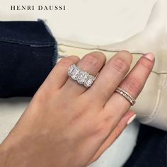 a woman's hand holding a diamond ring