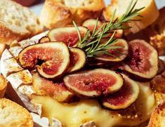 figs and cheese are piled on top of each other with rosemary sprigs