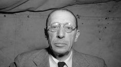 black and white photograph of man in suit with glasses looking off to the side while wearing eyeglasses