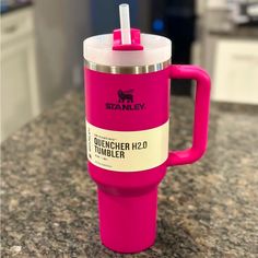 a pink coffee cup sitting on top of a counter