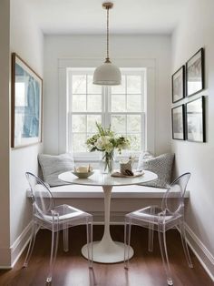 a dining room table with chairs and a bench in front of a window that has pictures on the wall