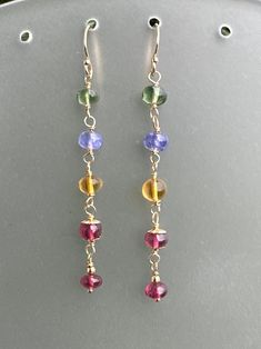 Charming gemstone earrings, wrapped in 14k gold filled wire, gorgeous gold filled beads and bead caps for embellishment. These earrings are 2 1/3 inches long. Ear wires are also 14k gold filled. Beautiful array of gemstones include apatite, tanzanite, citrine and rhodolite garnet. Lovely elegant accessories! Dangle Beaded Earrings With 14k Gold Filled, 14k Gold Filled Dangle Beaded Earrings With Gold Beads, Gold Wire Wrapped Beaded Earrings In 14k Gold Filled, Gold Hand Wrapped Dangle Earrings, Hand Wrapped Gold Drop Earrings, Gold Hand Wrapped Drop Earrings, Elegant Gold-colored Silver-plated Earrings, Elegant Hand Wrapped 14k Gold Filled Earrings, Gold Beaded Earrings Wire Wrapped In 14k Gold Filled