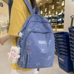 a woman carrying a blue backpack and a stuffed animal