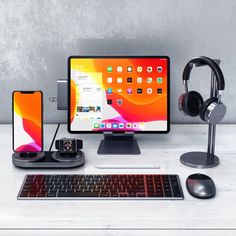 an apple desktop computer with headphones, keyboard and mouse on a desk next to it