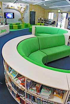 a curved couch sitting in the middle of a library