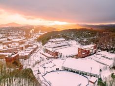 an aerial view of a city in the winter with snow on the ground and buildings