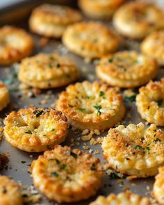 small appetizers are sitting on a baking sheet with parmesan cheese and herbs