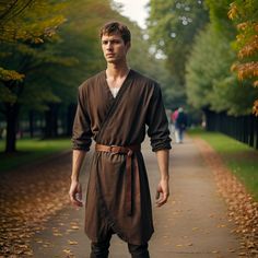 a man dressed in brown standing on a path