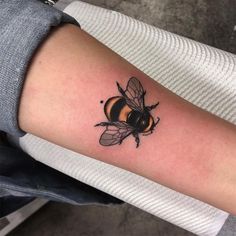 a woman's arm with a tattoo of a bee on it