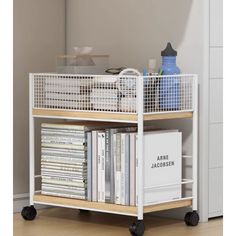 a white shelf with books and magazines on it in a room next to a wall