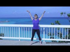 a woman standing in front of the ocean with her arms up