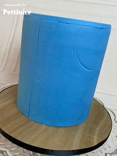 a blue hat sitting on top of a wooden table next to a white wall and floor