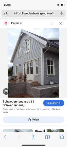 an image of a gray house with white trim on the front and side windows in german