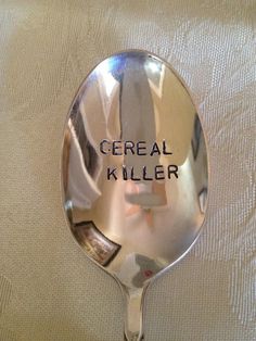 a metal spoon with the words cereal killer written on it's side and an arrow in the middle