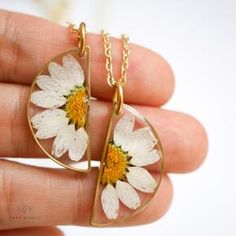 Set of half circle daisy necklaces being held in a hand. Everyday White Birth Flower Jewelry, White Flower Charm Jewelry For Friendship, White Jewelry With Flower Charm For Friendship, White Daisy Jewelry For Everyday, White Daisy-shaped Everyday Jewelry, Everyday White Daisy Shaped Jewelry, Adjustable Everyday Flower-shaped Jewelry, Adjustable Daisy Everyday Jewelry, Handmade Daisy-shaped Jewelry For Everyday