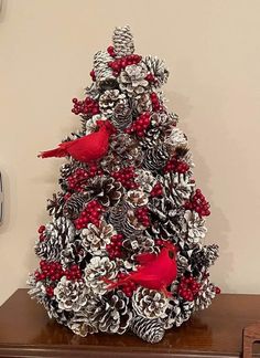 a christmas tree made out of pine cones and red birds