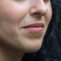 a close up of a woman with her nose pierced