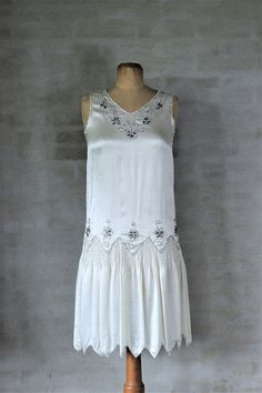 "1920s White Silk Dress with Glass Beads Gorgeous women's flapper style dress circa the 1920s. Ivory-coloured satiny fabric. Embellished with silver glass beads and rhinestones. Ruching at the dropped waist. No openings slip overhead. The dress is in very good condition for its age. There are no holes or tears and the beading appears to be intact. There are a few very light stains/areas of discolouration on the front of the dress. They are hard to see except for very close up. Size: Estimated Sm 1920s Formal Dress, 1920s Inspired Dresses, 1920 Dress, Womens Green Dress, Mary Dress, Great Gatsby Dresses, Flapper Style Dresses, Jazz Dress, Fringe Flapper Dress