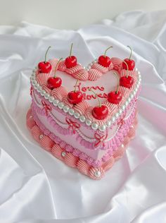 a heart shaped cake with cherries on top