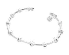 a silver bracelet with hearts on it and a heart charm in the middle, sitting against a white background