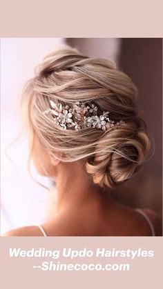 a woman wearing a wedding hair comb with flowers in her hair, looking down at the camera