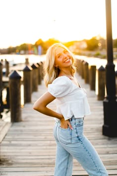 a woman posing on a dock with her hands on her hips