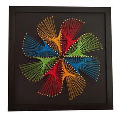 an art piece with multiple colored sticks arranged in the shape of a flower on a black background