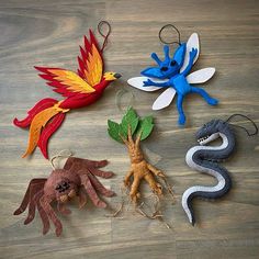 four different types of ornaments on a wooden table with leaves and branches in the shape of animals