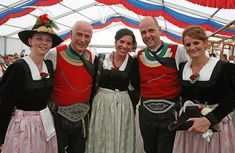 three men and two women dressed in costume posing for a photo at an outdoor event