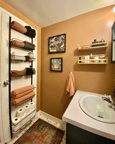 a bathroom with a sink and shelves on the wall