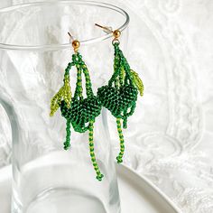 Green Heart and Leaves Beaded Earrings Beautify your style with these Green Heart and Leaves Beaded Earrings. Crafted with a unique green heart design, these handmade earrings feature a stunning beaded appearance. An ideal addition to your wardrobe, these earrings are perfect for any special occasion. Detail: Length of bracelet - around 15cm, adjustable for extra 5cm; thickness of bracelet - around 20mm Material: Beads - Acrylic; Stud - sterling silver; Buckle and chain - gold-plated bronze;  Note: the Green Heart and Leaves Beaded Earrings are handmade locally in the UK, each pieces would vary slightly in detail.  About postage: Standard postage When choosing standard postage, we assume this order is for yourself, or you will wrap the item yourself before giving it out as a gift (the comp Green Heart Beads Earrings For Gift, Green Earrings With Heart Beads For Gifts, Green Heart-shaped Bohemian Earrings, Green Beaded Chain Earrings, Green Beaded Earrings With Round Beads, Green Heart-shaped Jewelry With Colorful Beads, Handmade Green Heart Earrings As Gift, Handmade Green Heart Earrings For Gift, Green Dangle Earrings With Beaded Chain