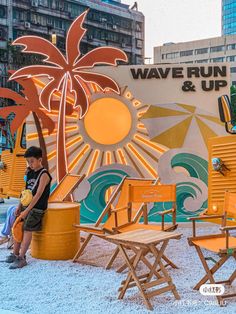 a man sitting on top of a yellow chair next to an orange and white sign