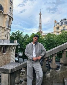 a man standing on top of a balcony next to the eiffel tower