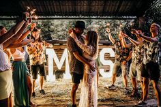 a group of people standing around each other with their hands in the air and holding sparklers