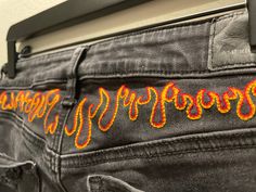 These hand embroidered jeans are sure to spark attention! Meticulously embroidered with fire engine red, clementine orange, and golden yellow. These rich colors are great for matching or being the center of your outfit.  Perfect from everyday streetwear with sneakers to a night out in heels! These jeans are previously loved and upcycled to bring some heat to your closet! Sizing: US - 6 - X-Long CA - 6 - Très Long MX - 6 - Ex Largo UK - 10 - X-Long Clementine Orange, Unique Jeans, Creative Clothes, Black Jeans Outfit, Black Jeggings, Eagle Black, Embroidered Pants, Jean Pockets, Football Outfits